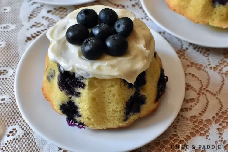 Mini Blueberry Bundt Cake with cream cheese frosting on a plate