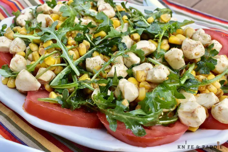 Tomato slices, topped with arugula, corn and mozzarella balls tossed in an olive oil and balsamic dressing