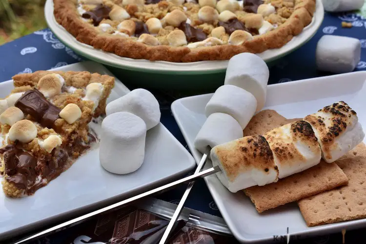 Slice of s'mores pie on a plate, s'mores pie, roasted marshmallows and graham crackers