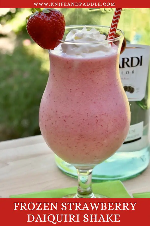 Frozen Strawberry Daiquiri Shake in a hurricane glass topped with whipped cream and a strawberry