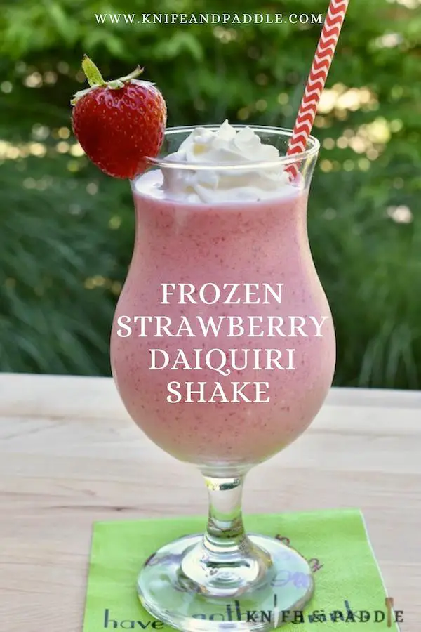 Frozen Strawberry Daiquiri Shake in a hurricane glass topped with whipped cream and a strawberry