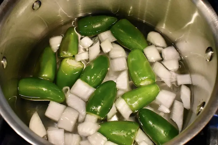 Water, onions and peppers in a sauce pan