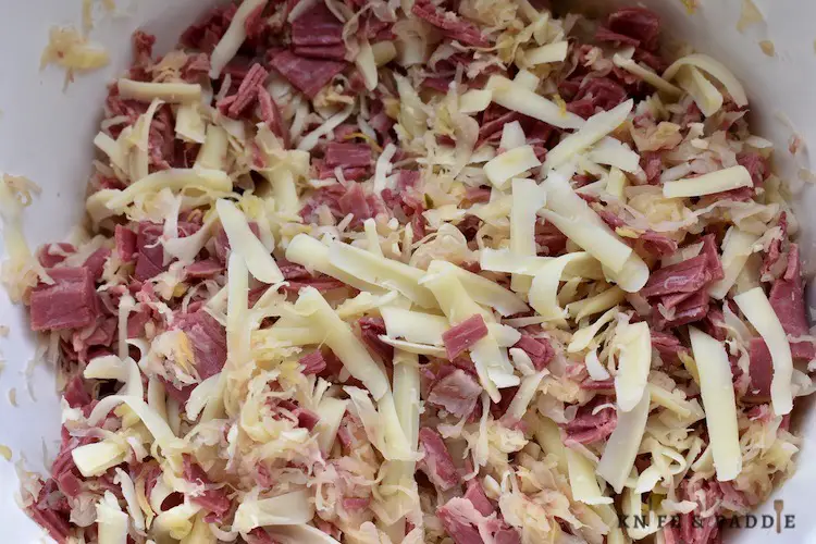 Shredded beef, shredded Swiss Cheese and sauerkraut in a mixing bowl