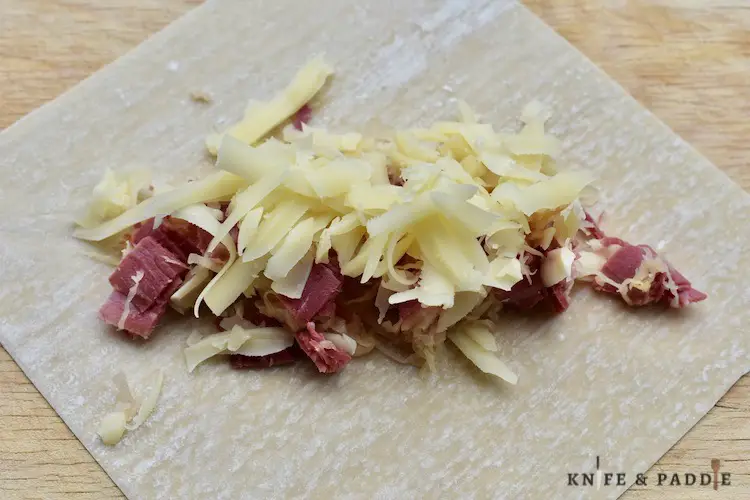 Egg roll wrapper filled with Swiss cheese, corned beef and sauerkraut 