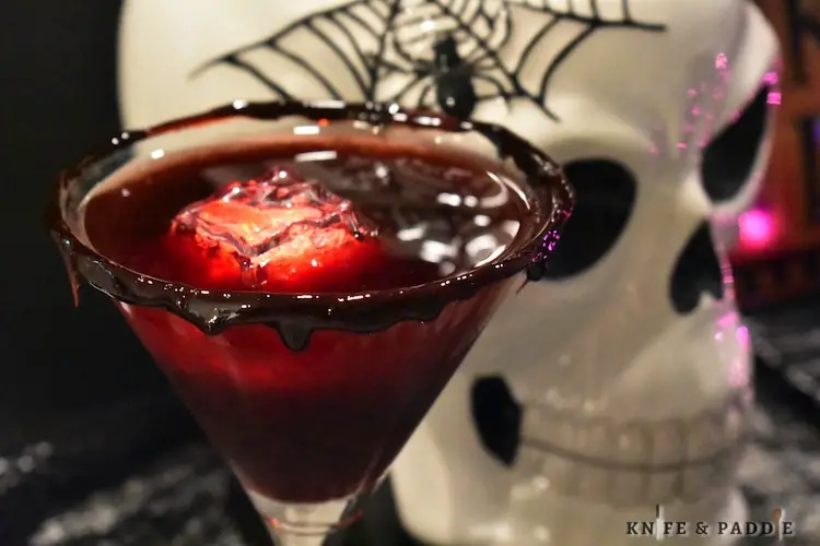 White rum, peach schnapps, black cherry juice strained in a blood dripped martini glass with a red LED ice cube