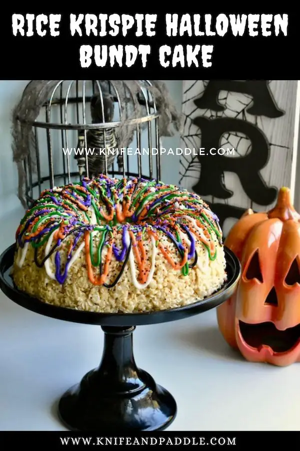 Rice cereal, butter, and marshmallows pressed into a round fluted pan decorated with orange, white, black, green and purple icing
