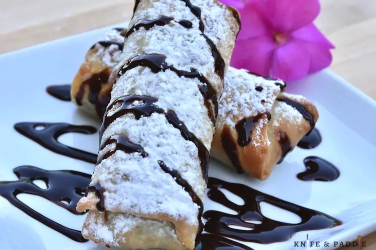 Pretty dessert with powdered sugar, drizzled with chocolate sauce
