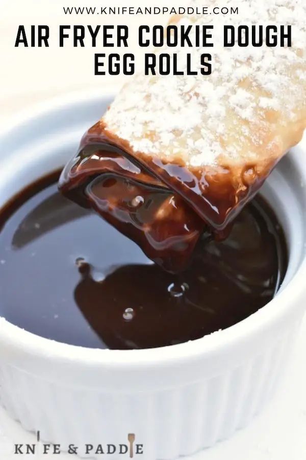 Air fryer cookie dough egg roll covered with powdered sugar dipped in chocolate sauce 