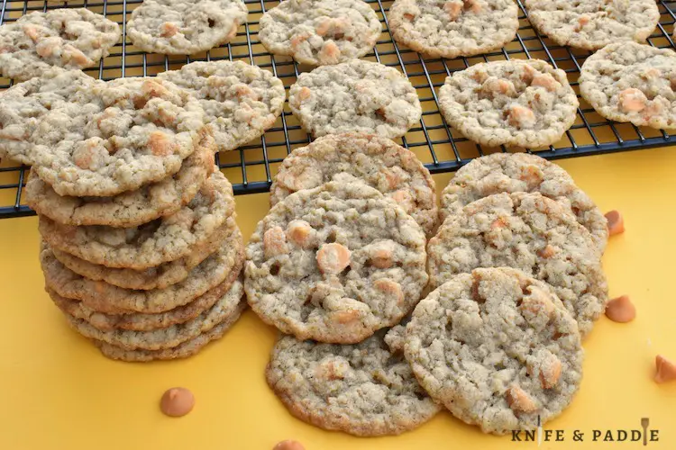 Oats and butterscotch chip cookies stacked and on a wire rack