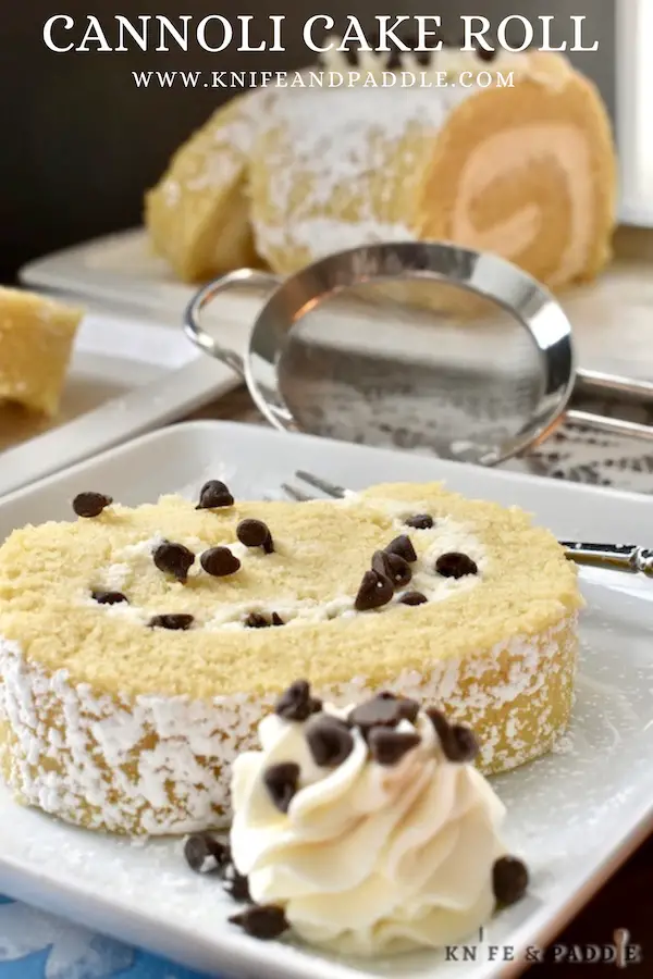 Cannoli Cake Roll with mini-chocolate chips and served with a dollop of whipped frosting