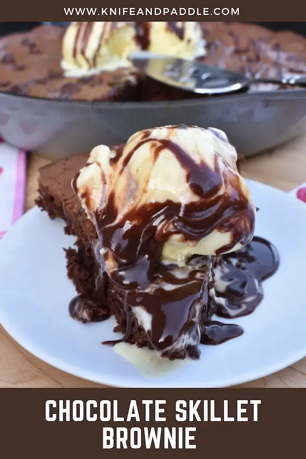 Slice of decadent dessert topped with vanilla ice cream and hot fudge