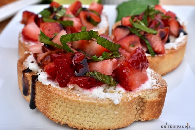 Strawberry-Goat Cheese Crostini on a plate drizzle with balsamic glaze and topped with fresh mint