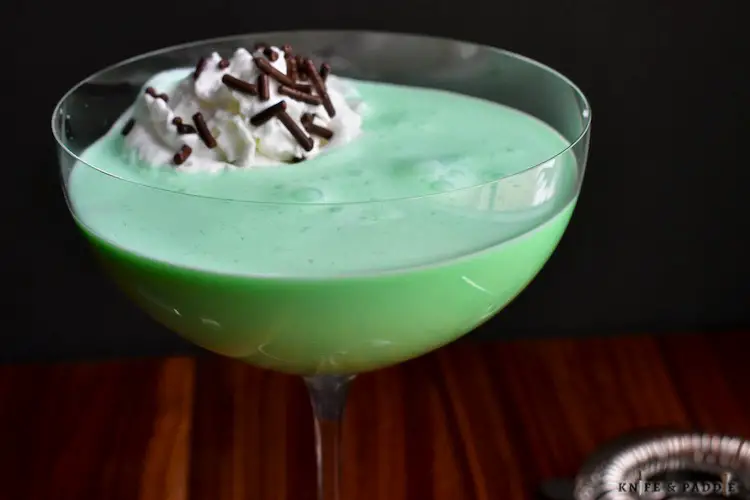 Creme de Menthe, Creme de Cacao and heavy cream shaken and poured into a coupe glass topped with whipped cream and chocolate sprinkles