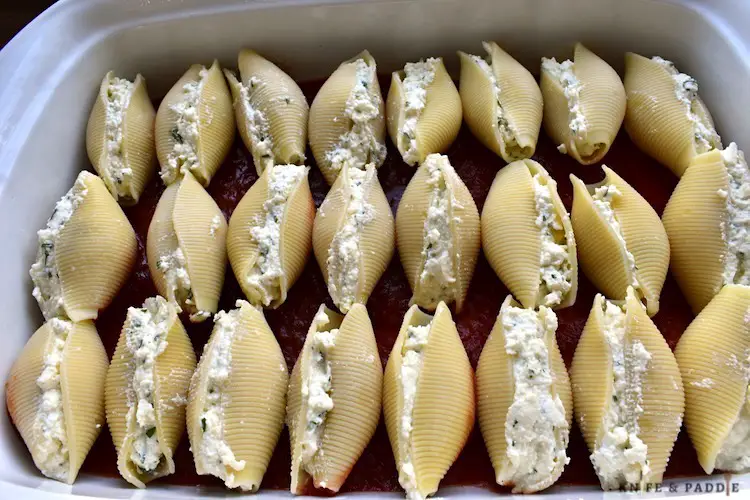 Pasta filled with ricotta, mozzarella, and parmesan cheese placed in a baking dish