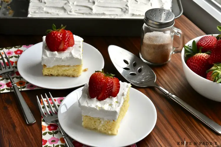 Tres Leches Cake with whipped cream frosting and topped with a strawberry
