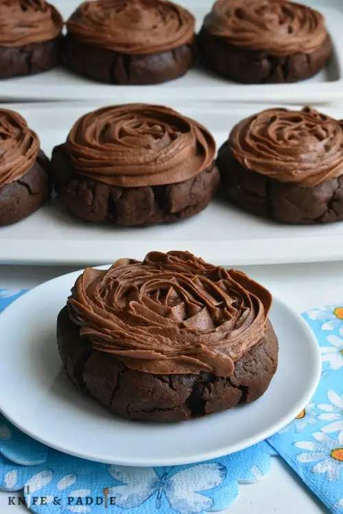 Copycat Chocolate Crumbl Cookies on plates with chocolate buttercream frosting