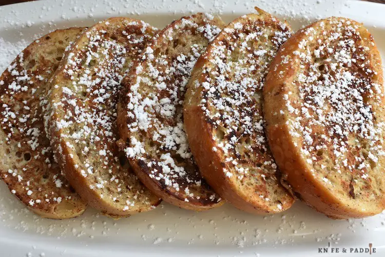 Homemade French Toast with powdered sugar on a serving plate