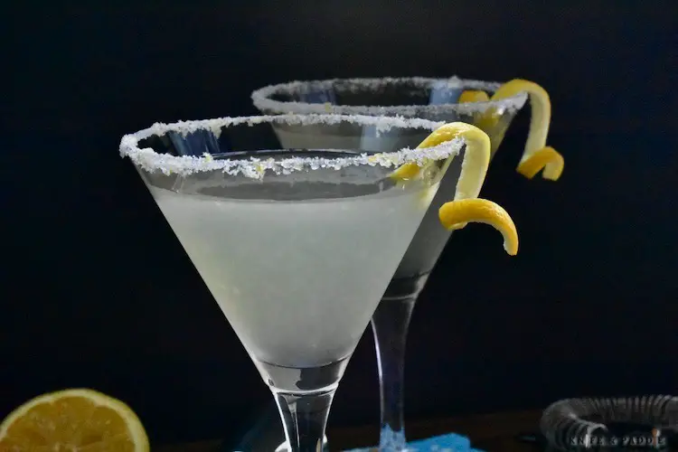 Lemon Drop Martinis served in a sugar and lemon zest rimmed martini glass garnished with a lemon twist