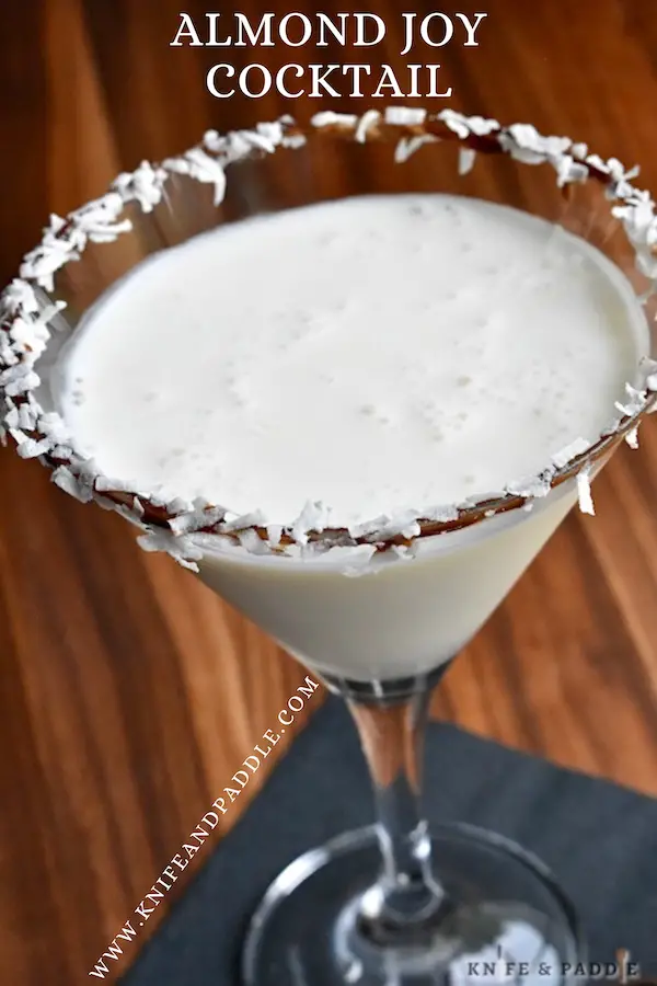 Almond Joy Cocktail in a martini glass rimmed with chocolate syrup and shredded coconut