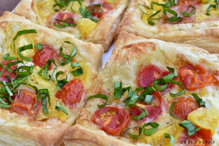 Puff Pastry topped with brie cheese, yellow and red grape tomatoes baked to a golden brown and topped with fresh basil