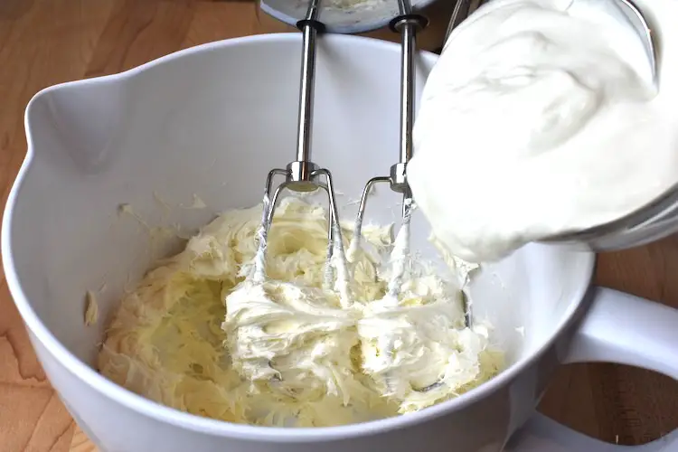 Beating cream cheese and adding sour cream