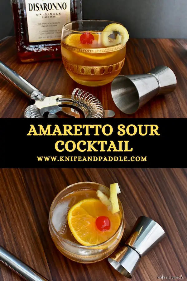 Amaretto Sour Cocktail in a rocks glass garnished with a lemon twist, orange slice and maraschino cherry