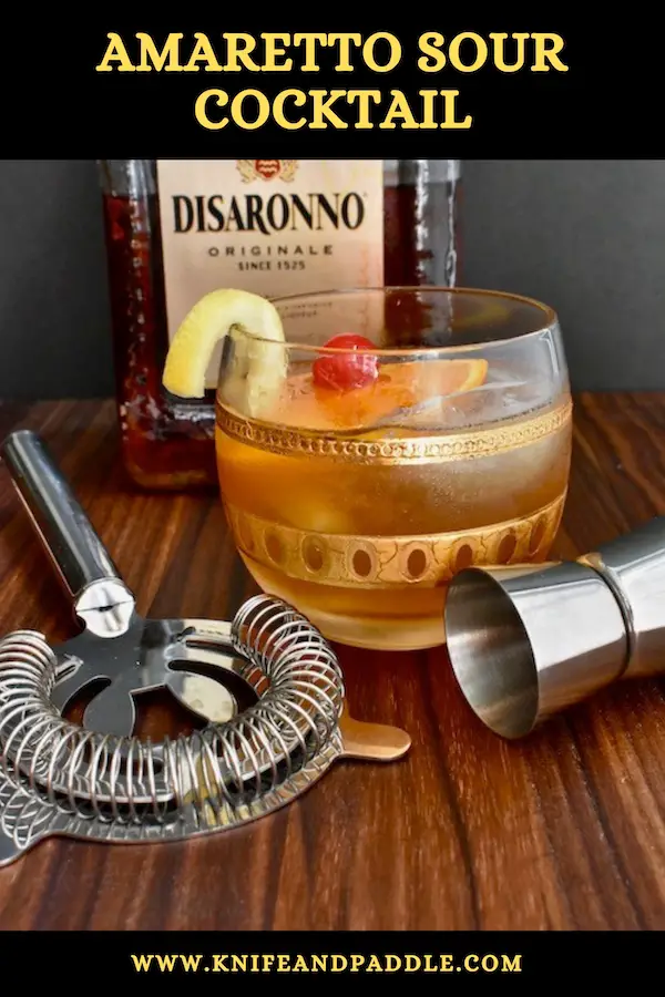 Italian Cocktail with a nutty libation, citrus and simple sugar in a rocks glass with ice garnished with a lemon twist, orange slice and maraschino cherry
