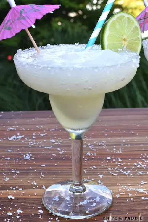 Refreshing slushy summer cocktails with a lime wheel and cocktail umbrella