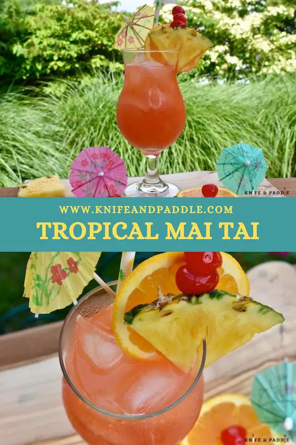 Refreshing, fruity summer cocktail in a hurricane glass garnished with a pineapple slice, orange slice and a cocktail umbrella
