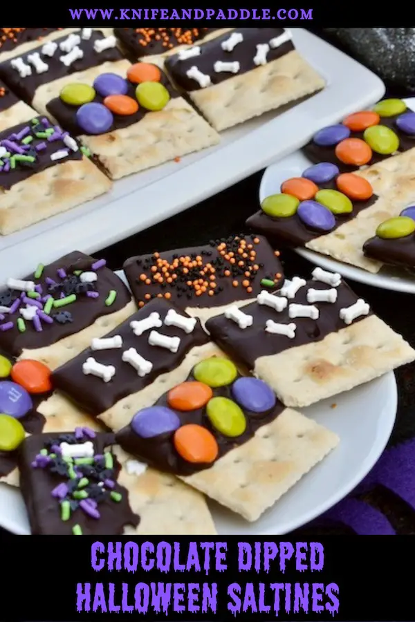 Chocolate Dipped Halloween Saltines on a plate with Halloween sprinkles and M&M's