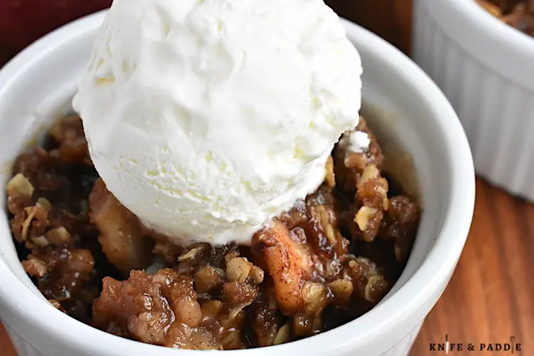 The Best Apple Crisp in a bowl topped with vanilla ice cream