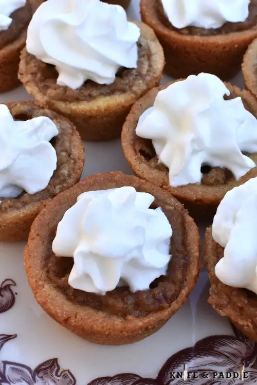 Mini Pecan Bites with whipped cream on a plate