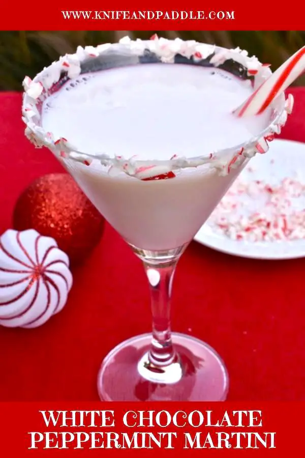 Peppernint schnapps, Godiva White Chocolate Liqueur, vodka combined and poured in a candy cane rimed glass and a candy cane for garnish
