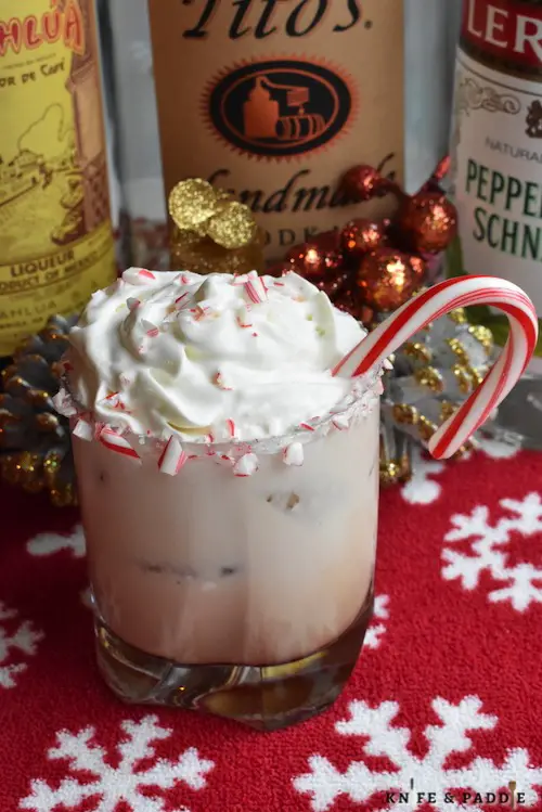 Vodka, Kahlúa, Peppermint Schnapps and heavy cream stirred together in a lowball glass rimmed with crushed candy canes and topped with whipped cream, crushed candy canes and a candy cane for garnish