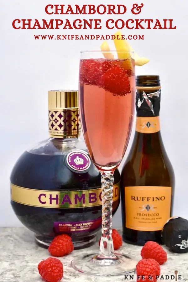 Chambord and Champagne Cocktail topped with fresh raspberries and a lemon twist for garnish 