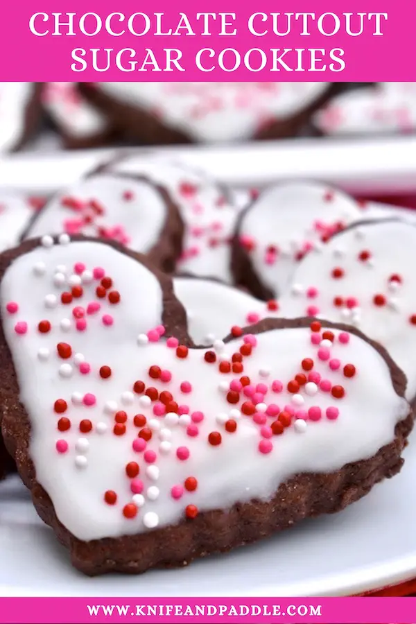Chocolate Cutout Sugar Cookies heart shaped with vanilla frosting and red, white and pink nonpareils 