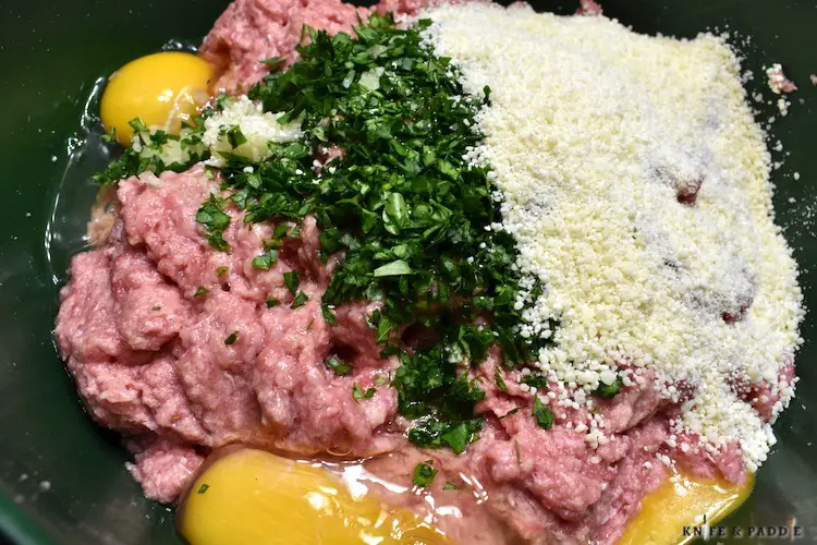 Ground beef, garlic, parsley, eggs, salt, pepper and parmesan cheese in a mixing bowl
