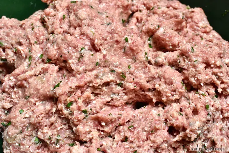 Ground beef, garlic, parsley, eggs, salt, pepper, parmesan cheese and wet stale bread mixed together in a mixing bowl