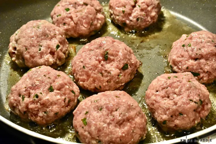Rolled ground beef in a frying pan