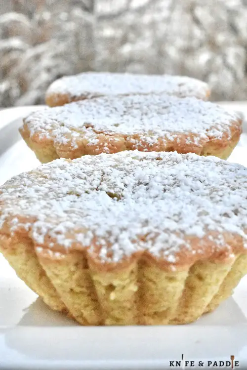 Pasticiotti sprinkled with powdered sugar on a plate