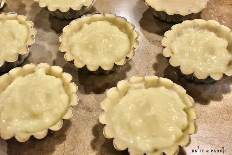 Pressed dough into mini tart pans and filled with vanilla custard 3/4 way full