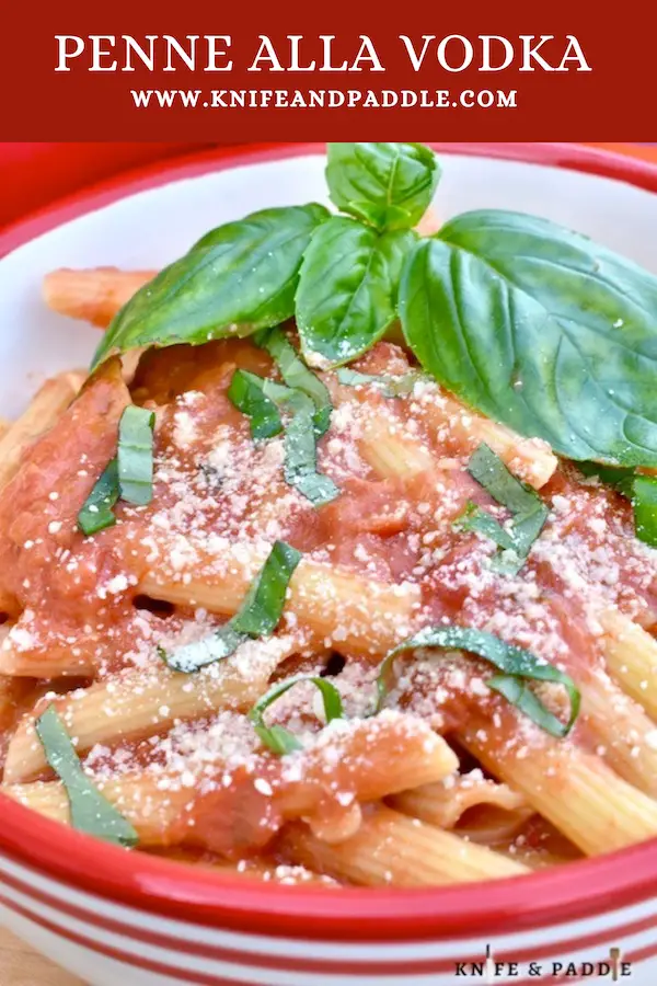 Simple Penne alla Vodka topped with fresh basil and parmesan cheese in a bowl