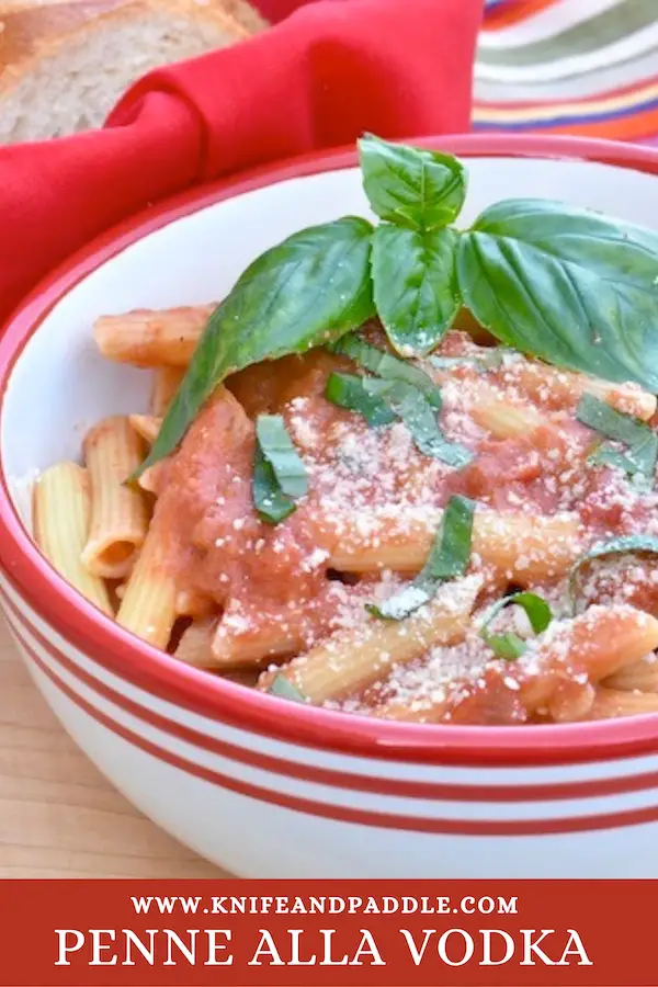 Classic Italian Pasta Dinner with a rich tomato cream sauce in a bowl topped with fresh basil and parmesan cheese