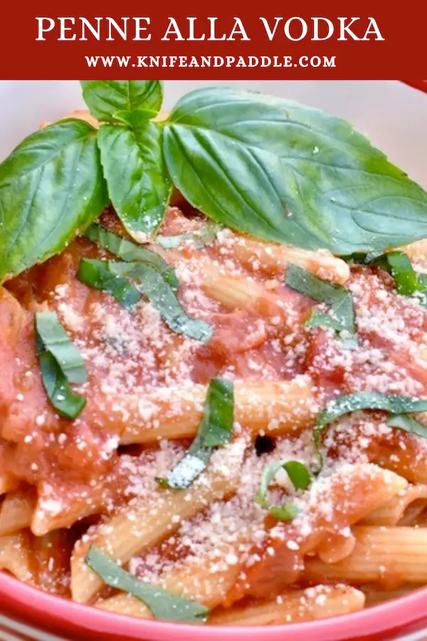 Simple Penne alla Vodka topped with fresh basil and parmesan cheese in a bowl
