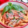 Penne alla Vodka in a bowl with fresh basil and parmesan cheese