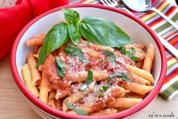 Penne alla Vodka in a bowl with fresh basil and parmesan cheese