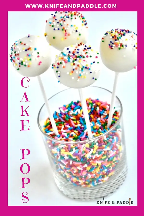 Cake pops with festive nonpareils in a glass full of rainbow sprinkles
