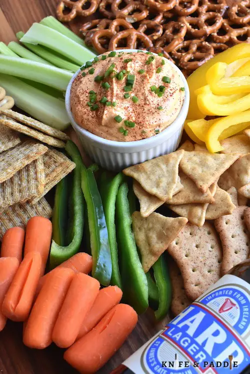 Cold dip with crackers, pretzels, and veggie sticks