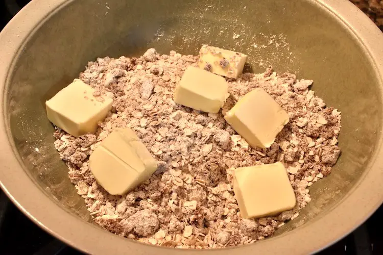 In a microwavable bowl, oats, flour, brown sugar and butter (cubed). 