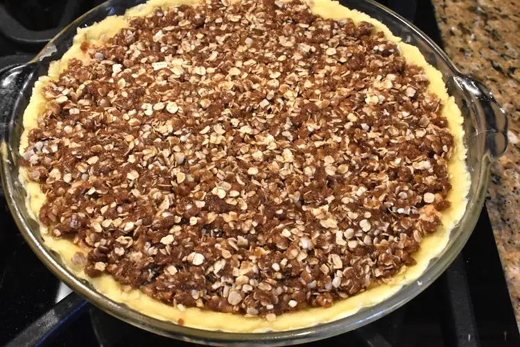 Assembled peanut butter pie with an oat and dark brown sugar topping